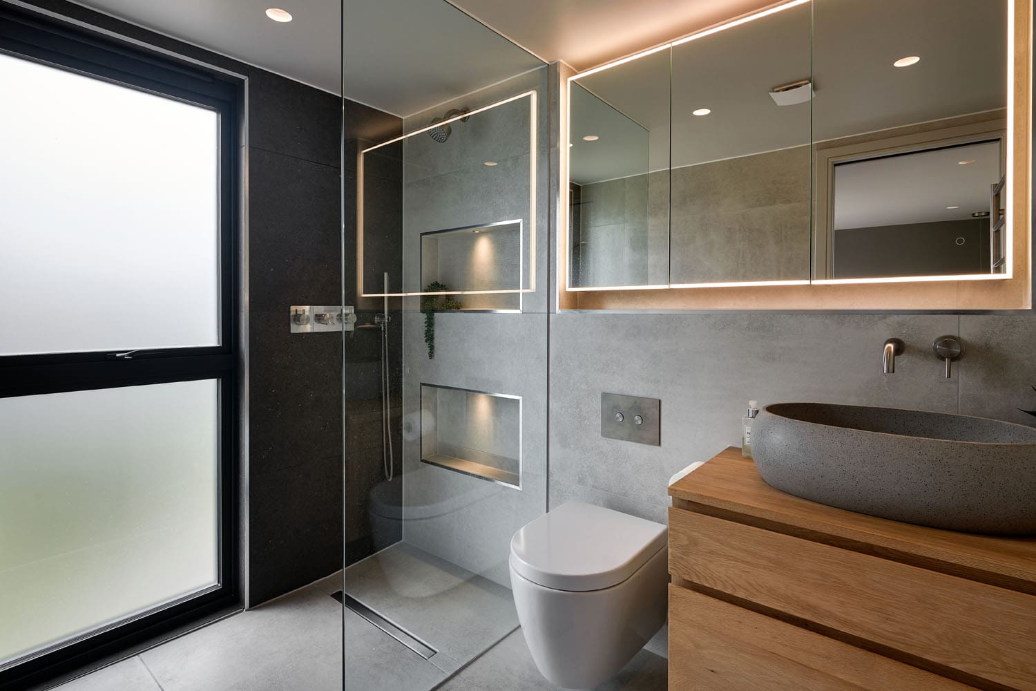 dusty grey loft bathroom with glass wet room shower and mounted fixtures
