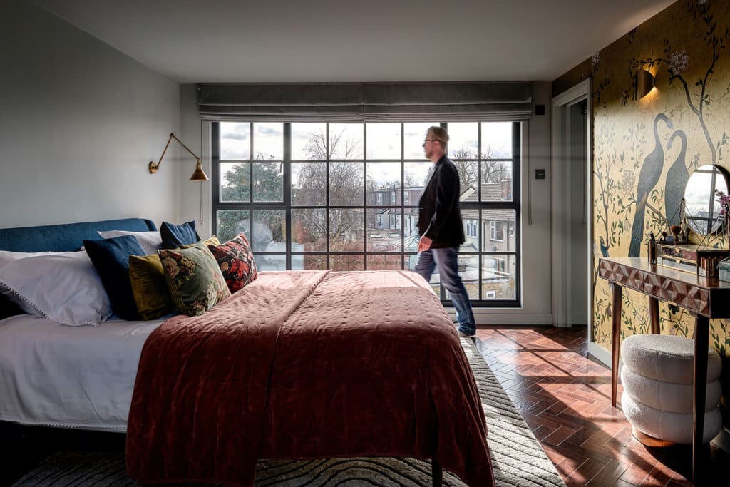 man walking across loft conversion in front of dormer windows